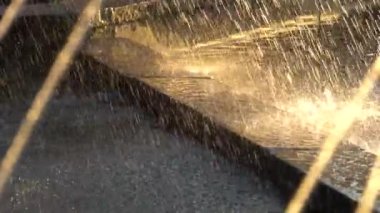 Çeşme günbatımı ışınları sıçramasına su jetleri. HD slowmotion x4