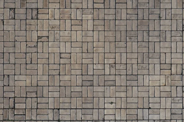 正方形のパターンが付いている灰色の舗装石。歩行者道路、舗装または歩道。道路の背景 — ストック写真