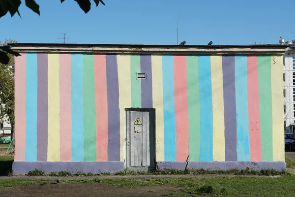 City technical building with bright painted streaked concrete wall