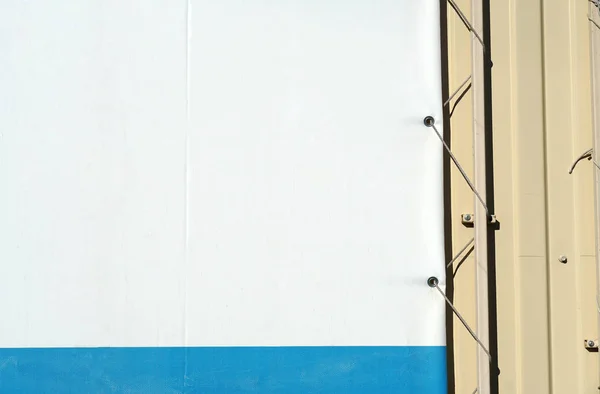 Fragment leeren Straßenbanner mit Befestigungselementen. Posterkante an Metallwand — Stockfoto