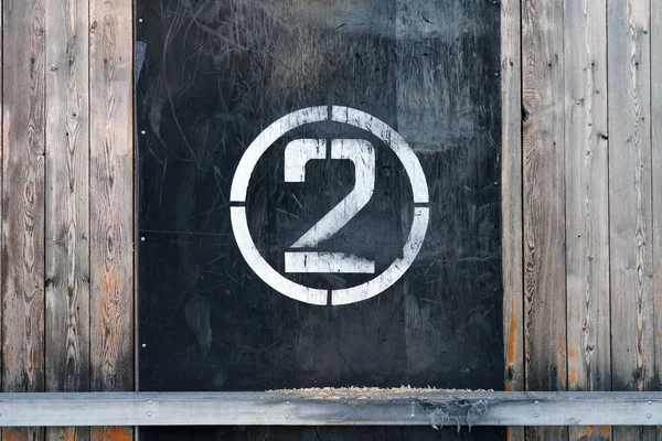 Νούμερο 2 σε κύκλο, σε παλιό λαστιχένιο πανό στον τοίχο του σταδίου. Λευκή σφραγίδα νικητή με γρατσουνιές σε μαύρο φόντο — Φωτογραφία Αρχείου