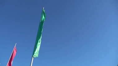 Dar dikey bayrak mavi gökyüzüne karşı rüzgarda sallayarak. Spor görüntüleri 4k