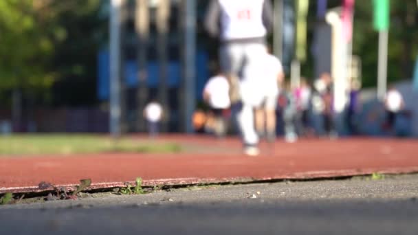 Blurred background of runners on provincial stadium. Amateur sport footage slow — Stock Video