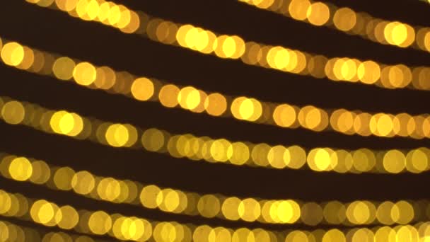 Bokeh de guirlandas cintilantes de Ano Novo borradas. Fundo de Natal bonito de luzes douradas quentes. 4K Ultra HD — Vídeo de Stock