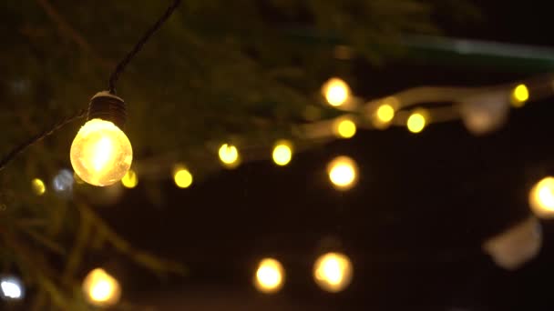Close-up New Years bol van Garland en weinig sneeuwval op achtergrond van flikkerende lichten. Kerstmis wazig 4k Ultra HD — Stockvideo