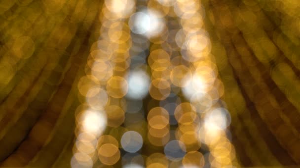 Боке размытых новогодних гирлянд. Красивый рождественский фон из теплых золотых огней. 4K Ultra HD — стоковое видео