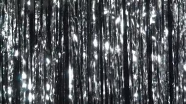 Simli gümüş yağmuru. Parlak ışıklarda ve parlak parçacıklarda dinamik arkaplan. Parlak gümüş parıltılı ışıltılarıyla güzel gümüş bir arka plan. Şenlik havası. Noel ya da tatil teması