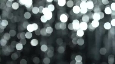 Gümüş çözünmüş bokeh ile soyut parlak arkaplan. Parlayan ışıklar ve ışıldayan parçacıklarda güzel dinamik bir arkaplan. Şenlik havası. Noel ya da tatil teması