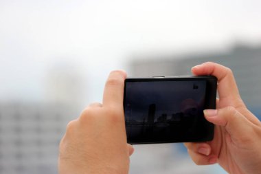 İnsan elinden tutarak ve bir fotoğraf çekmek için bir smartphone ekran dokunaklı.