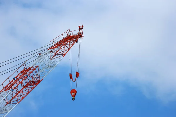stopped high red crane with blue sky clouds as copy space background.