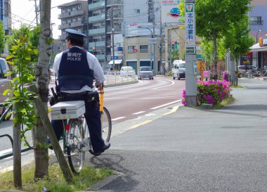 2017 Nisan 05. Tokyo Japonya. Bisiklet üzerinde bir polis, Edokawa kentinde nüfusun Safty arıyor.