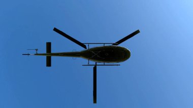 3d render. Mavi gökyüzü arka planda uçan siyah metal helikopter düşük açı görünümü.