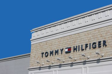 2019 March 26. Tochigi Japan. a modern design of TOMMY HILFIGER brand name logo wall with blue sky background at sano tochigi outlet mall. clipart