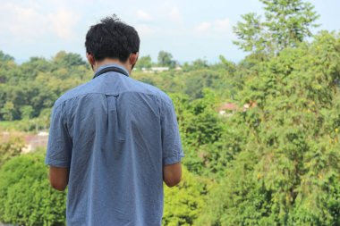 Asyalı kameraman yeşil doğal manzaranın fotoğrafını çekiyor..