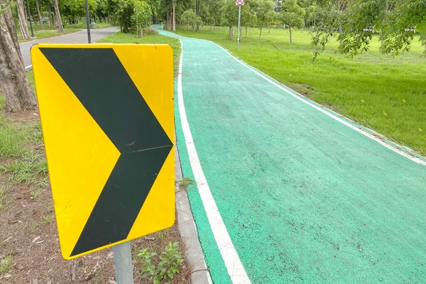 Açık hava parkında bisiklet şeridini temizlemek için asfalt ok yönü.