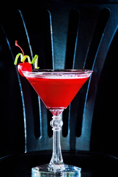 Red drink cocktail with cherry in martini glass, cherry and lime peel — Stock Photo, Image