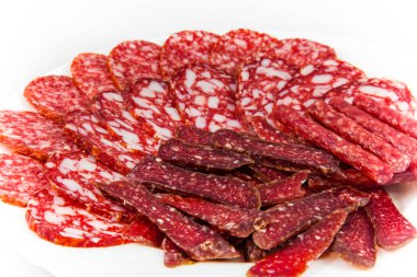 Dilimlenmiş füme sosisler beyaz tabakta, yakın.