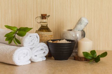 Spa, güzellik ve sağlık geçmişi: havlu, kozmetik masaj yağı, taze yaprak, deniz tuzu ve mum.
