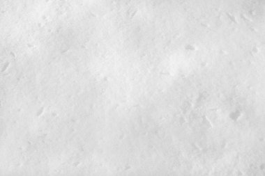 Açık ve güneşli bir günde yerde beyaz kar. Kar dokusu.