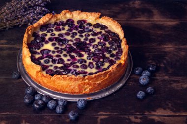 Yaban mersinli, ahşap bir zemin ve bir buket kurutulmuş lavanta ile doldurulmuş yaban mersinli roston turtası.