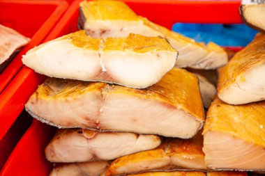 Tütsülenmiş Kamçatka balığı satışı. Uzak Doğu deniz ürünleri, doğal tütsülenmiş balıklar. Noel pazarında inconnu somonu..