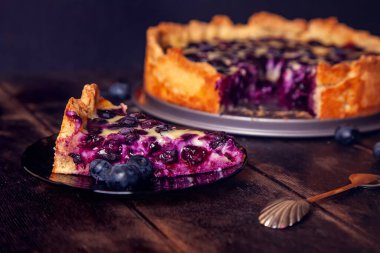 Yabanmersinli, kır ekmeği turtası ahşap bir zemine doluyor ve çay tabağı ve kaşıkla kesilmiş..