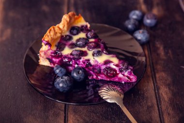 Yabanmersinli, kır ekmeği turtası ahşap bir zemine doluyor ve çay tabağı ve kaşıkla kesilmiş..