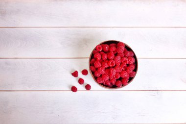 Beyaz ahşap zemin üzerinde hindistan cevizi kabuğu kabuğu ahududu, üst görünüm kopya spase