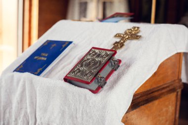 Ortodoks Kilisesi 'nde vaftiz töreni. Dua kitapları ve masada bir haç..