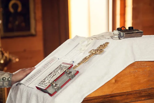 正教会での洗礼の秘跡 テーブルの上で祈りの本と十字架 — ストック写真