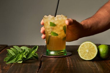 Bir barda içkiye hazır bir mojito ile el ele tutuşmak yaz için içki kavramı.