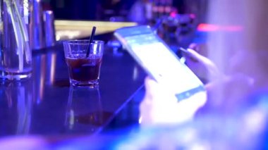 evde bir akıllı telefon ile bir gece kulübü içecekler bir barda kadın