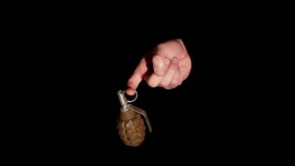 男子手里拿着手榴弹 准备在黑色背景特写镜头上戴戒指 — 图库视频影像