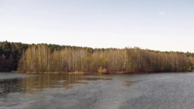 Büyük nehir, gökyüzü olan ağaçların arka planına karşı. Bahar.