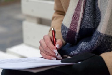 Bir el ve kalem bir form tamamlama görüntüsü. Kalem ile pastel manikür kadın eller.