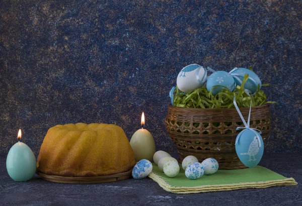 复活节面包和蓝色复活节彩蛋放在黑暗石桌上的篮子里 — 图库照片