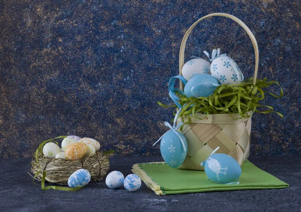 Easter basket with coloured Easter eggs on dark stone table