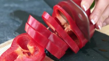 Kırmızı biber Dilimleme işlemi. Siyah taş masa üzerinde kırmızı pul biber.