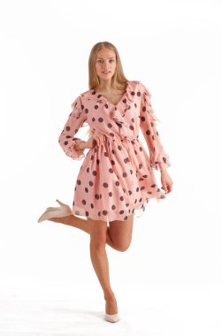 Beyaz arka plan üzerinde izole pembe polka nokta elbise güzel genç sarışın kadın