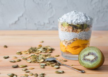 Bir chia bir cam granola, mango ve bir kivi ile sağlıklı vanilya puding