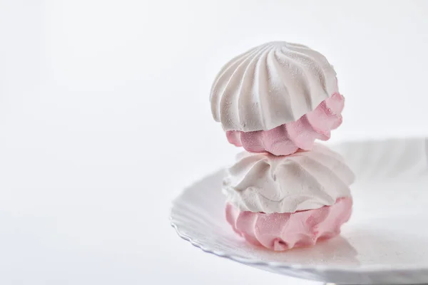Zephyr bianco-rosa su un piatto bianco su uno sfondo bianco . — Foto Stock