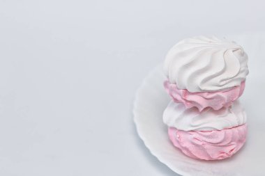 Beyaz bir arka plan üzerinde beyaz bir plaka üzerinde beyaz-pembe zephyr. 