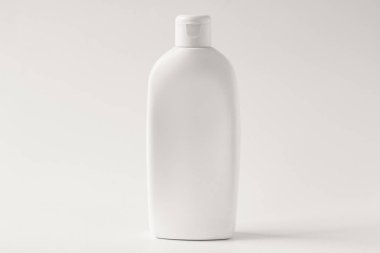 Krem beyaz bir arka plan üzerinde beyaz plastik şişe. Önden Görünüm.