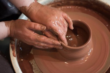 Potter'ın tekerlek ve kil eşya üstünde o yukarıda alınan döner. A sculpts potter's tekerlek kil bardakta elleriyle. Kil elinde. 