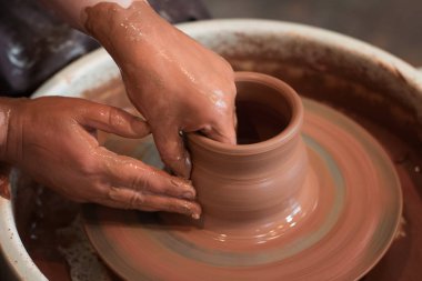 Potter'ın tekerlek ve kil eşya üstünde o yukarıda alınan döner. A sculpts potter's tekerlek kil bardakta elleriyle. Kil elinde. 
