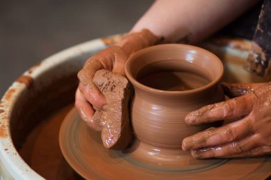 Potter'ın tekerlek ve kil eşya üstünde o yukarıda alınan döner. A sculpts potter's tekerlek kil bardakta elleriyle. Kil elinde. 
