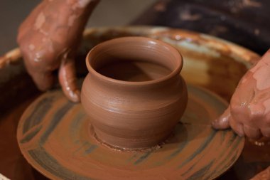 Potter'ın tekerlek ve kil eşya üstünde o yukarıda alınan döner. A sculpts potter's tekerlek kil bardakta elleriyle. Kil elinde. 
