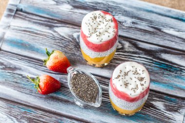 Mango ile Chia puding, Doğal yoğurt, Chia, ahşap bir masada bir bardak vahşi çilek. Sağlıklı tatlı, süper gıda 