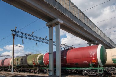 Tankları ile yük treni şehir istasyonunda üstgeçit altında raylar üzerinde duruyor. Petrol ve yakıt ile tren tankları