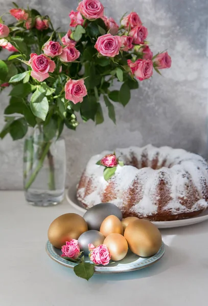 Torta di Pasqua tradizionale con uova di Pasqua e mazzo di rose su sfondo grigio. Composizione pasquale . — Foto Stock